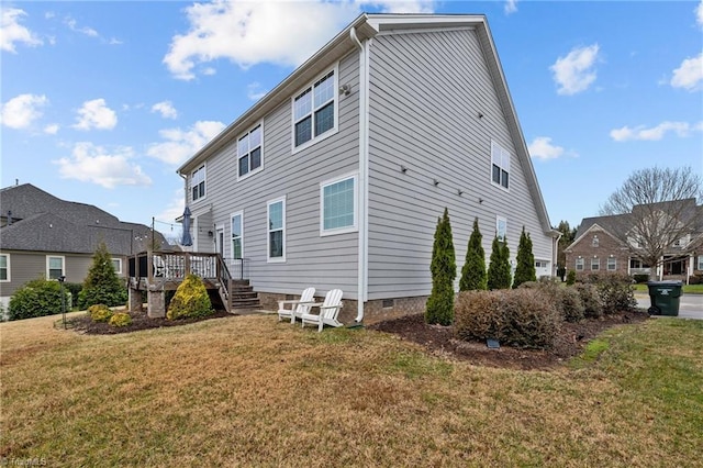 rear view of property with a deck and a lawn