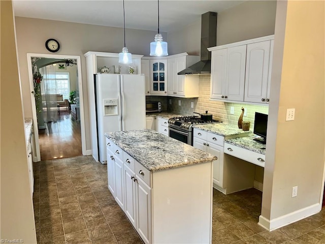 kitchen with wall chimney range hood, white cabinets, stainless steel gas stove, and white fridge with ice dispenser