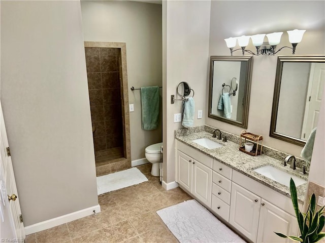 full bath with double vanity, a tile shower, toilet, and a sink