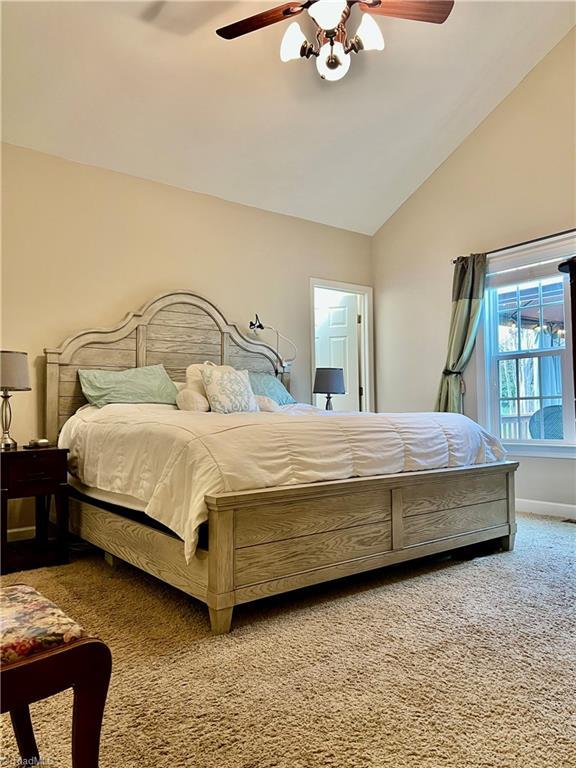 bedroom featuring baseboards, lofted ceiling, carpet, and ceiling fan