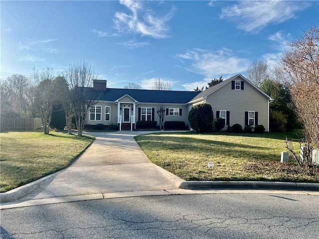 ranch-style house featuring concrete driveway, fence, a front lawn, and a chimney