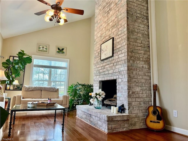 living area with high vaulted ceiling, wood finished floors, a fireplace, baseboards, and ceiling fan