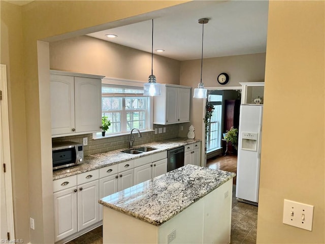 kitchen featuring a sink, stainless steel microwave, white fridge with ice dispenser, decorative backsplash, and dishwasher