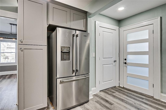 kitchen featuring light wood-style flooring, gray cabinetry, baseboards, and stainless steel fridge with ice dispenser