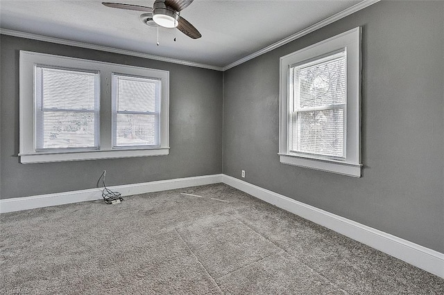 carpeted empty room featuring plenty of natural light, baseboards, and crown molding