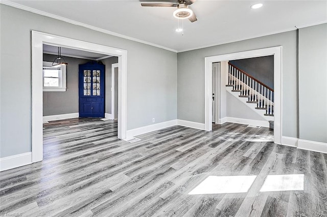 interior space featuring ornamental molding, wood finished floors, and baseboards