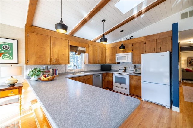 kitchen featuring decorative light fixtures, white appliances, and kitchen peninsula