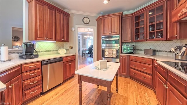 1250 Whitworth Ct, Kernersville, NC 27284 - kitchen featuring stainless steel appliances, exhaust hood, decorative backsplash, light wood-style flooring, and glass insert cabinets