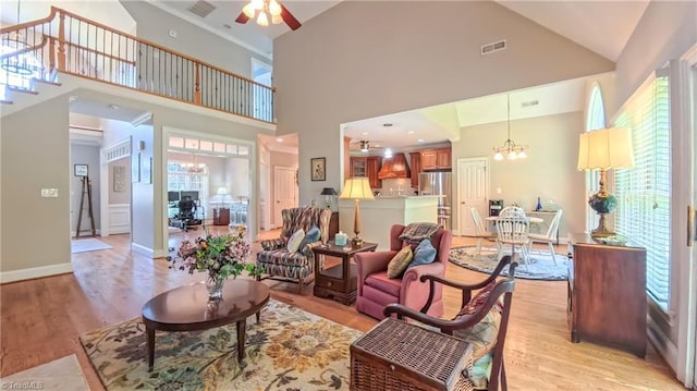 1250 Whitworth Ct, Kernersville, NC 27284 - living room featuring a chandelier, light wood-style floors, ceiling fan, and high vaulted ceiling