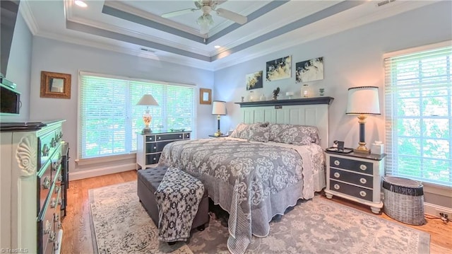 1250 Whitworth Ct, Kernersville, NC 27284 - bedroom featuring crown molding, multiple windows, wood finished floors, and a tray ceiling