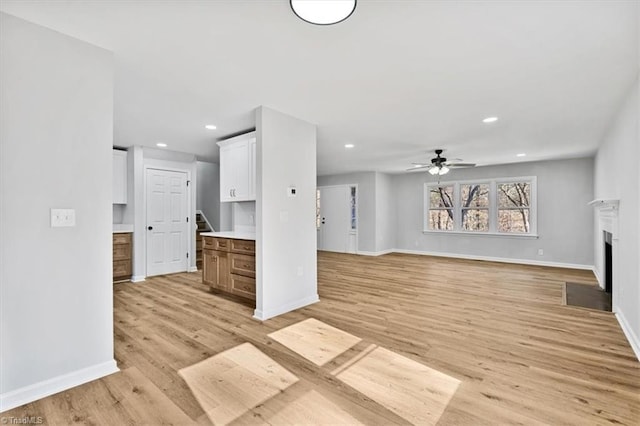 unfurnished living room with ceiling fan and light hardwood / wood-style floors