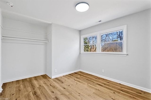 unfurnished bedroom with a closet and light hardwood / wood-style flooring