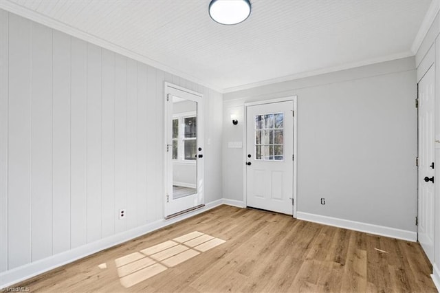 spare room featuring crown molding and light wood-type flooring