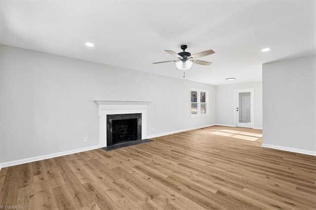 unfurnished living room featuring ceiling fan and light hardwood / wood-style floors