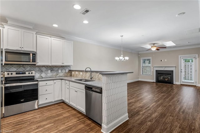 5707 Washburn Ln, Colfax, NC 27235 - kitchen featuring appliances with stainless steel finishes, a sink, a peninsula, tasteful backsplash, and a fireplace