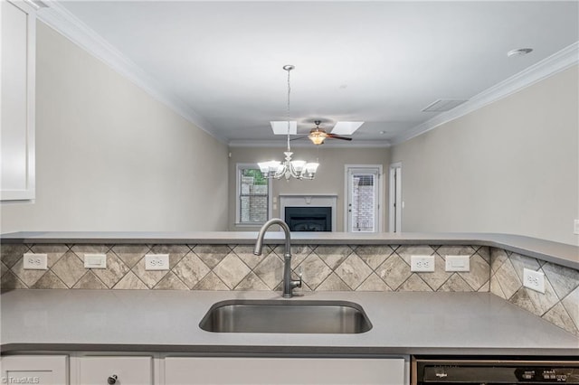 5707 Washburn Ln, Colfax, NC 27235 - kitchen featuring a sink, dishwashing machine, white cabinets, a chandelier, and ornamental molding