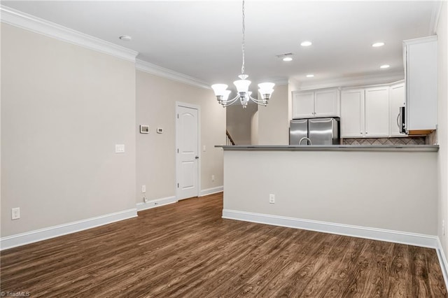 5707 Washburn Ln, Colfax, NC 27235 - kitchen featuring stainless steel appliances, ornamental molding, white cabinetry, a chandelier, and dark wood-type flooring