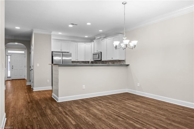 5707 Washburn Ln, Colfax, NC 27235 - kitchen with stainless steel appliances, ornamental molding, dark countertops, dark wood-type flooring, and baseboards