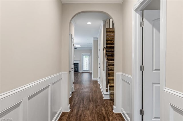 5707 Washburn Ln, Colfax, NC 27235 - hall featuring crown molding, arched walkways, dark wood-style flooring, a wainscoted wall, and a decorative wall