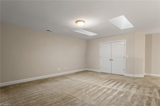 5707 Washburn Ln, Colfax, NC 27235 - unfurnished bedroom featuring a skylight, light carpet, and baseboards