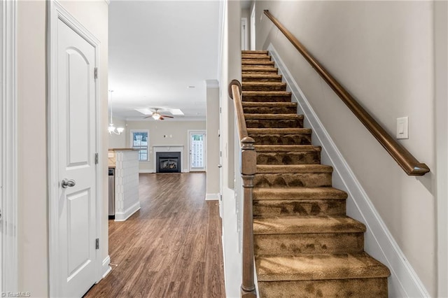 5707 Washburn Ln, Colfax, NC 27235 - stairs with wood finished floors, a fireplace, ceiling fan, and baseboards