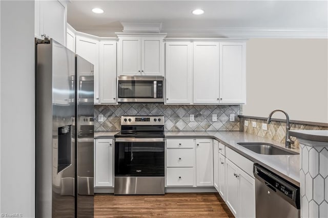 5707 Washburn Ln, Colfax, NC 27235 - kitchen with appliances with stainless steel finishes, a sink, white cabinetry, dark wood-style flooring, and backsplash
