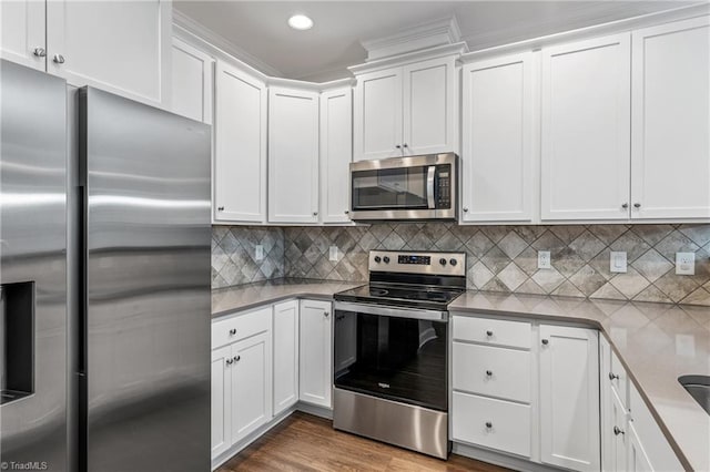 5707 Washburn Ln, Colfax, NC 27235 - kitchen with appliances with stainless steel finishes, white cabinets, backsplash, recessed lighting, and wood finished floors