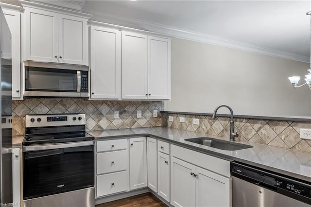 5707 Washburn Ln, Colfax, NC 27235 - kitchen featuring appliances with stainless steel finishes, a sink, ornamental molding, white cabinets, and a chandelier