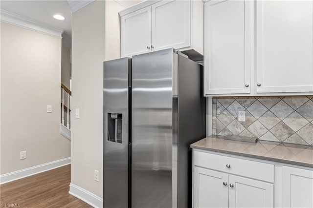 5707 Washburn Ln, Colfax, NC 27235 - kitchen featuring stainless steel fridge, tasteful backsplash, baseboards, white cabinets, and crown molding
