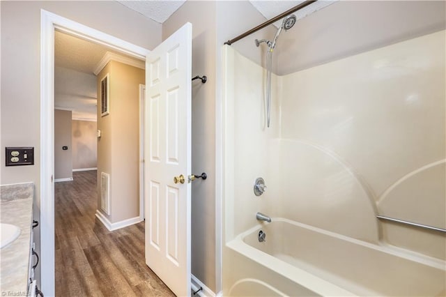 bathroom featuring hardwood / wood-style flooring, vanity, and  shower combination