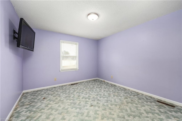 unfurnished room featuring a textured ceiling and carpet flooring