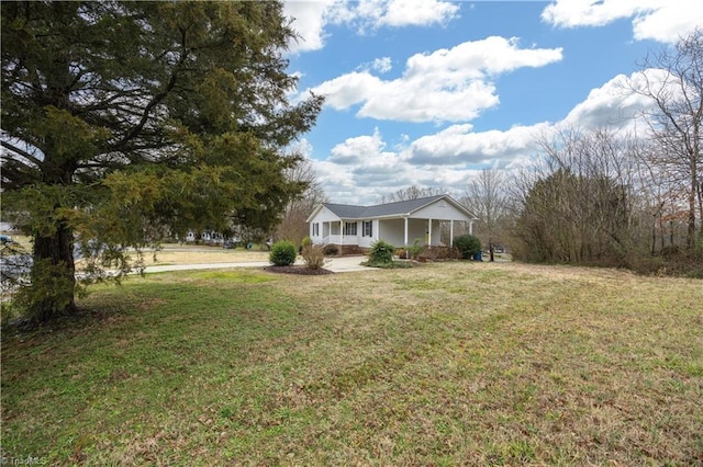 ranch-style house featuring covered porch and a front yard