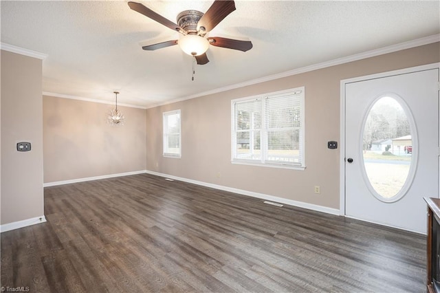 entrance foyer featuring ceiling fan with notable chandelier, a textured ceiling, dark hardwood / wood-style floors, and ornamental molding