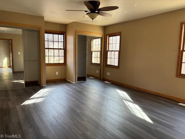 spare room featuring dark wood-type flooring and ceiling fan