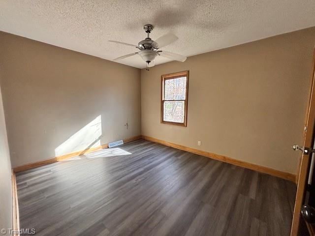 spare room with ceiling fan, dark hardwood / wood-style flooring, and a textured ceiling