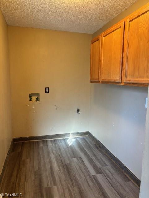 laundry room with cabinets, dark hardwood / wood-style flooring, hookup for a washing machine, and a textured ceiling