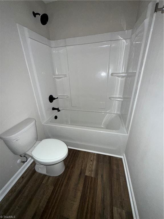 bathroom with wood-type flooring, toilet, and shower / tub combination