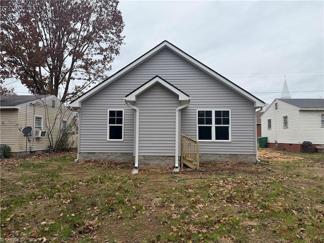 back of property featuring cooling unit and a yard