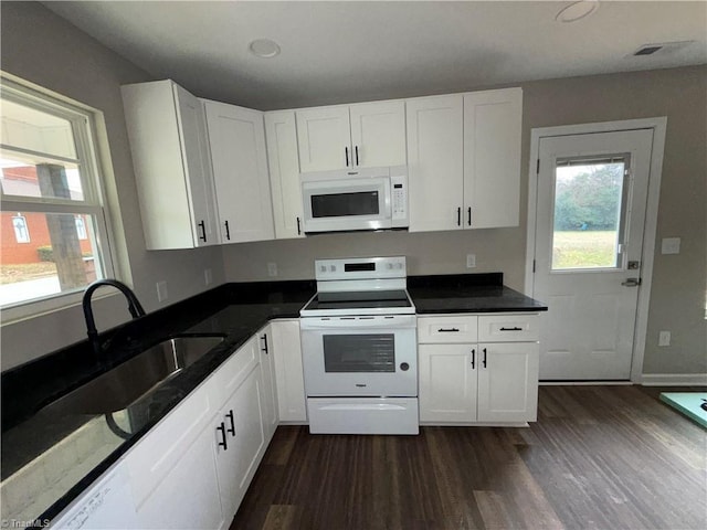 kitchen featuring white appliances, dark wood-type flooring, and white cabinets