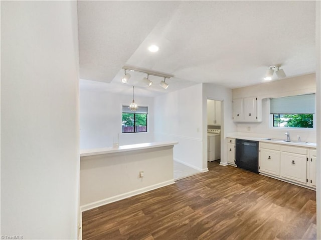 kitchen with dishwasher, rail lighting, dark wood-type flooring, white cabinets, and washer / clothes dryer