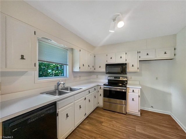 kitchen with black appliances, a sink, dark wood-style floors, baseboards, and light countertops