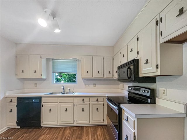 kitchen with black appliances, a sink, dark wood-style flooring, light countertops, and white cabinets
