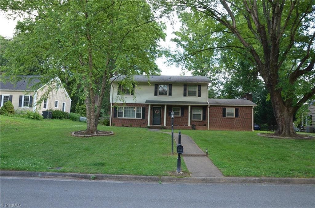 1613 Normandy Ln, Winston-Salem, NC 27103 - traditional-style home with a front lawn, brick siding, and a chimney