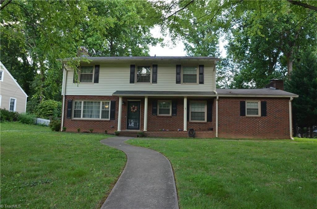 1613 Normandy Ln, Winston-Salem, NC 27103 - traditional-style house featuring a chimney, a front yard, and brick siding