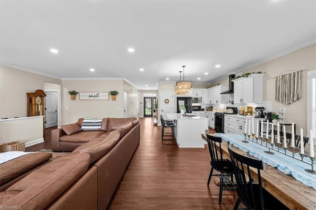 living area with dark wood-type flooring, recessed lighting, baseboards, and ornamental molding