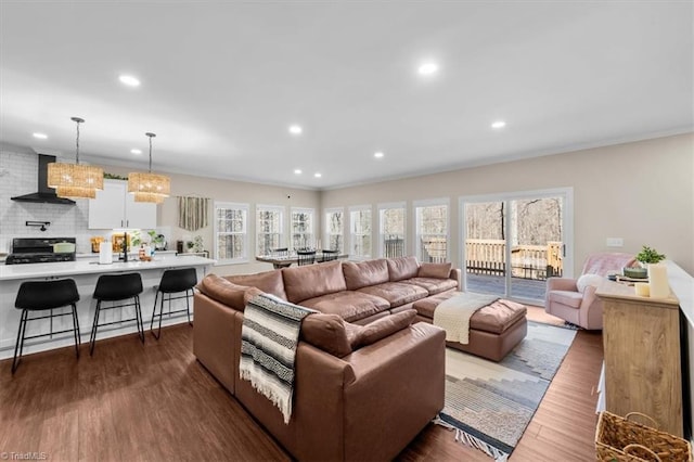 living area with recessed lighting, ornamental molding, and dark wood-style flooring