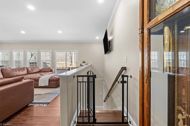 stairway featuring recessed lighting, baseboards, wood finished floors, and ornamental molding