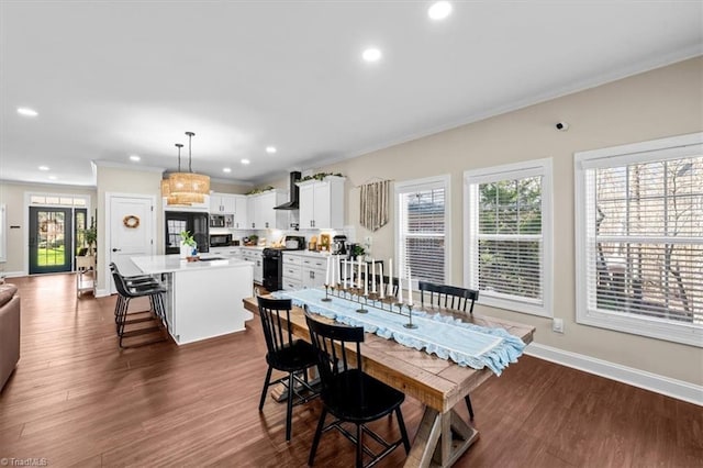 dining room featuring recessed lighting, crown molding, dark wood-type flooring, and baseboards