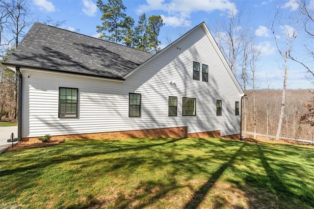 back of house with a lawn and roof with shingles