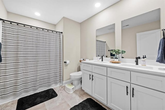 bathroom featuring a sink, toilet, a shower with shower curtain, and double vanity